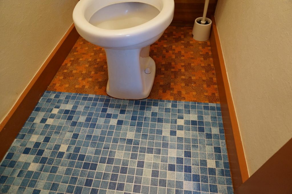 セリアのリメイクシートをトイレの床に貼り付けているところ